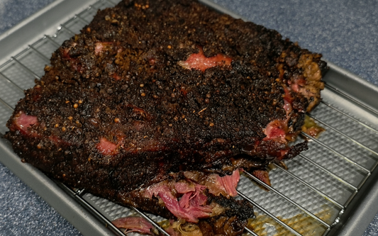 Full rack of beef rib pastrami with black pepper coriander bark on cooling rack - NY BBQ Guys smoked beef ribs recipe