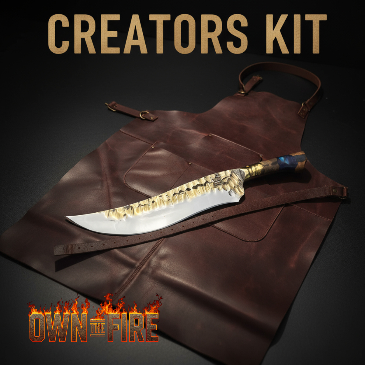 Leather creator’s apron with a custom forged knife displayed on top, with the text ‘Creators Kit’ and the Own The Fire™ flame logo