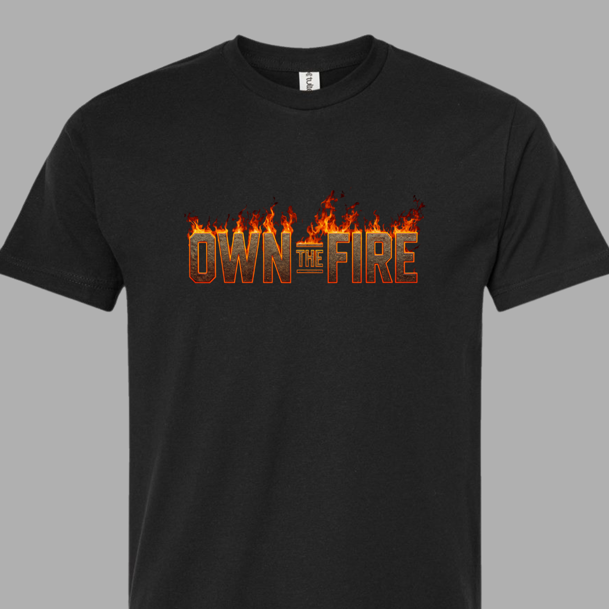 Black t-shirt with 'OWN THE FIRE' text and flames on a gray background