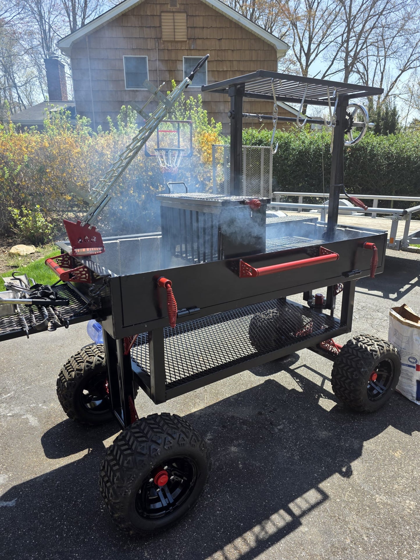 Portable barbecue grill on wheels with a smoking lid in an outdoor setting.