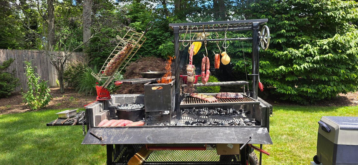 Outdoor grill setup with various meats hanging and on the grill in a backyard setting.