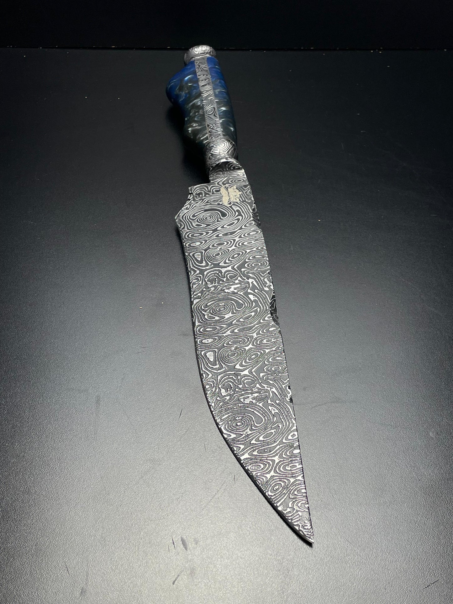 Decorative knife with an engraved blade on a dark background
